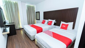 Habitació d'hotel amb dos llits, un escriptori i una televisió.