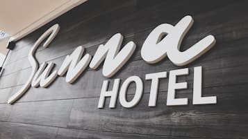 A sign with the words "Sun Hotel" in a stylized font on a wooden wall.