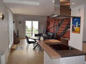 Enjoy a compact kitchen with a central island, dining area, and cozy seating in this apartment.