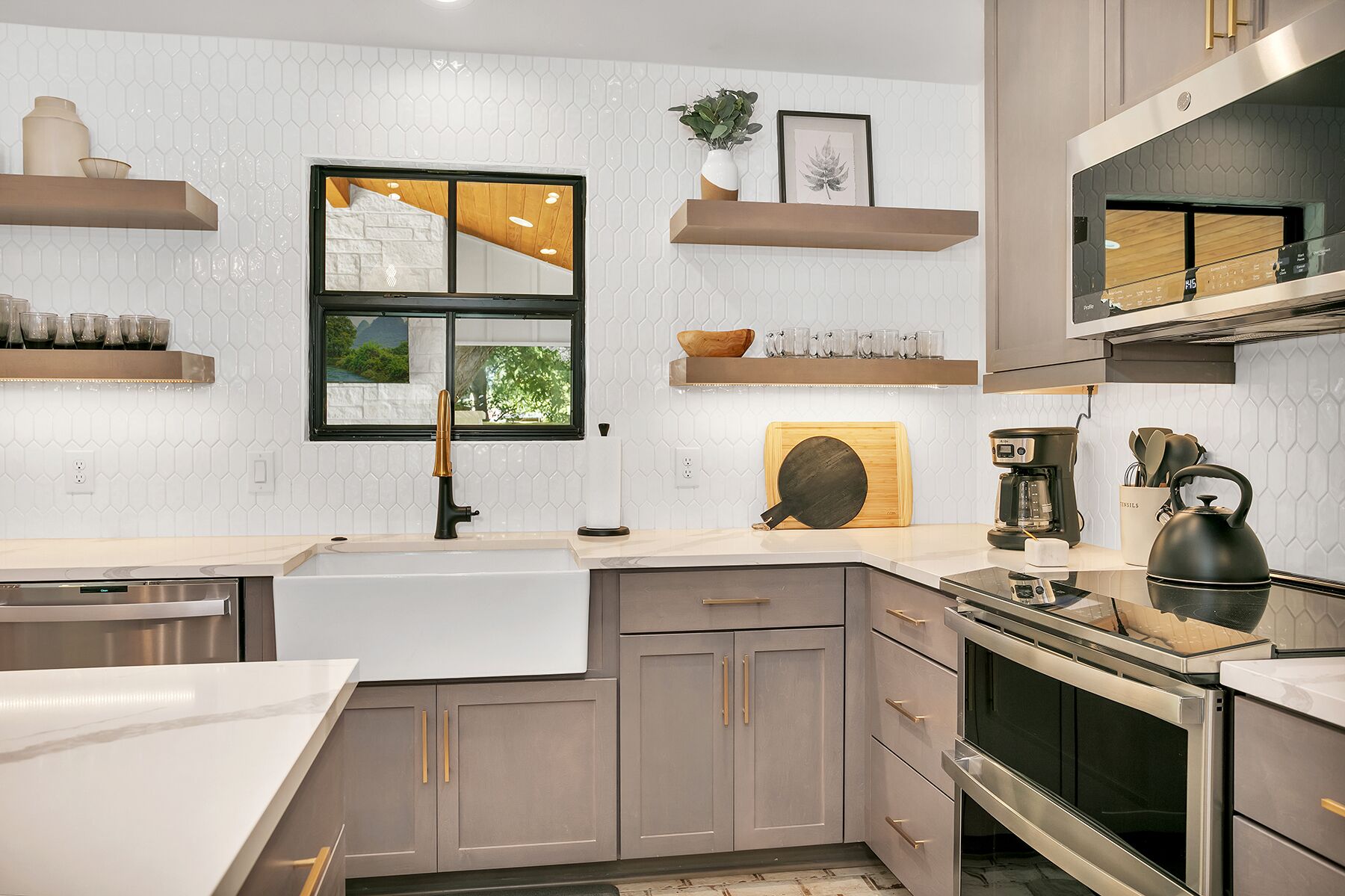 A modern kitchen with a large window, built-in appliances, and wooden cabinets.