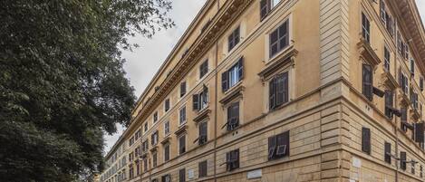 Un edificio de varios pisos con estilo arquitectónico clásico, que presenta una fachada simétrica con ventanas uniformemente espaciadas y una entrada central.