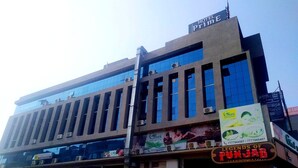 A multi-story building with a sign for Hotel Prime on the top. - Hotel Prime (Gandhinagar)