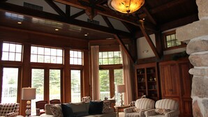 A spacious living room with large windows, wooden beams, and a stone accent wall. - First Floor Allegheny Springs with Private Entrance-free pool use,slopeside,A/C (dunmore)