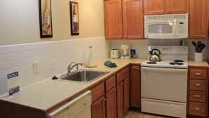 A kitchen with wooden cabinets, a white microwave, a stove, a sink, and a coffee maker. - First Floor Allegheny Springs with Private Entrance-free pool use,slopeside,A/C (dunmore)