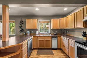 A modern kitchen with wooden cabinets, a built-in dishwasher, and a granite countertop.