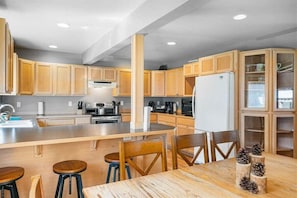 Una cocina moderna con armarios de madera, una isla central y taburetes de bar.