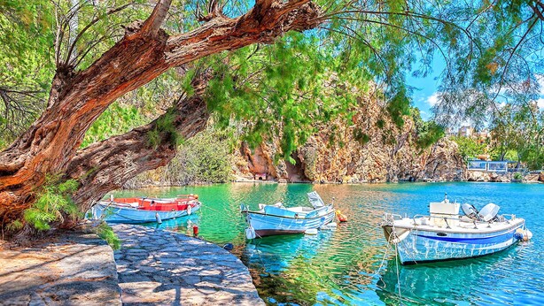 A serene lakeside scene with boats docked near a stone pathway. - Etoile Villa Heated Pool (Agios Nikolaos)