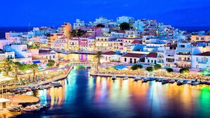 A coastal town with colorful buildings, a marina, and a calm waterfront. - Etoile Villa Heated Pool (Agios Nikolaos)