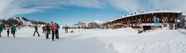 A snow-covered ski resort with wooden buildings and a clear sky. - Hotel Enzo Moro (Sutrio)