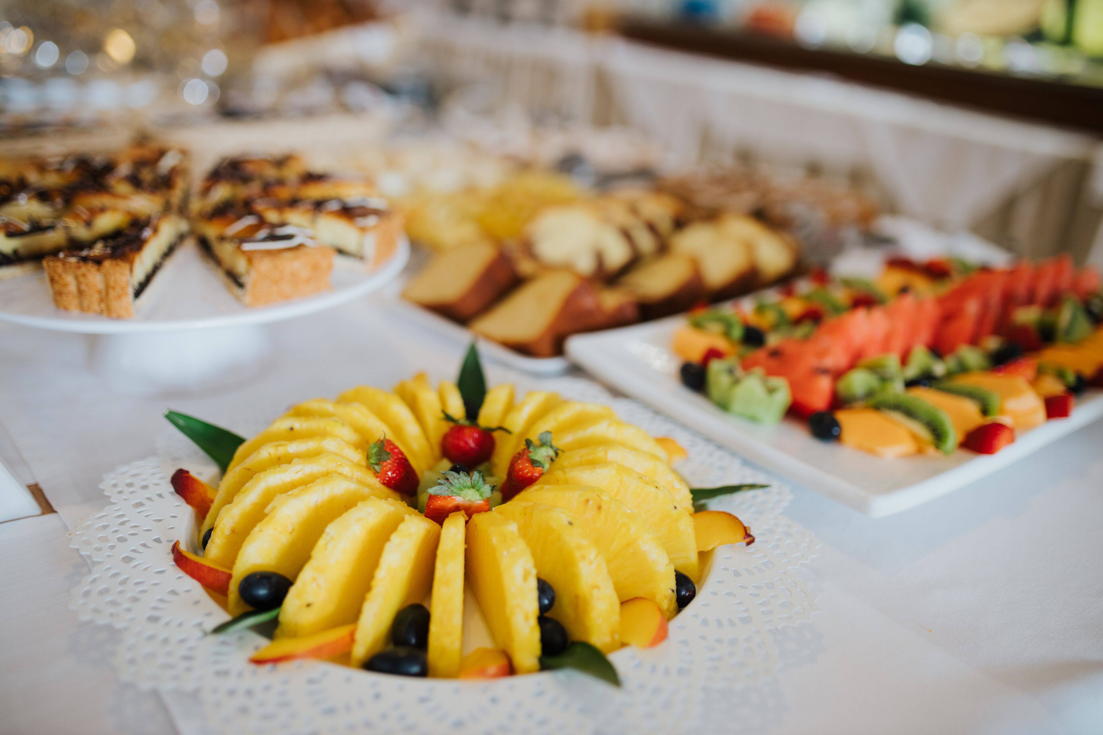 Een buffet met diverse desserts en fruitstukken.