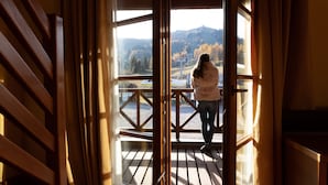 A person standing on a balcony with a view of a mountainous landscape. - Hotel Enzo Moro (Sutrio)