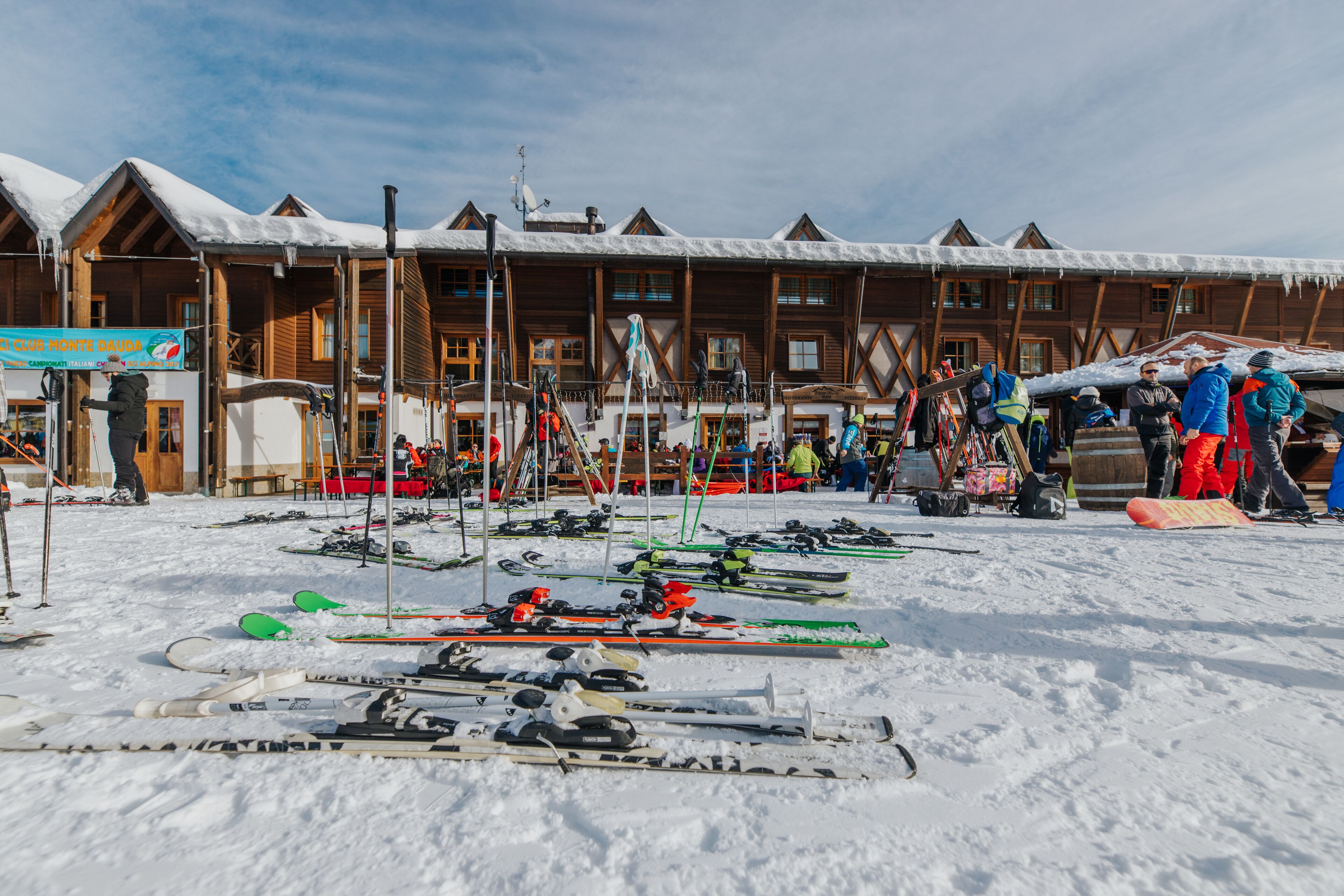 Ein Skigebiet mit Holzhäusern, Skiausrüstung und verschneitem Gelände.