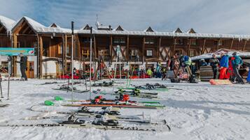 Ein Skigebiet mit Holzhäusern, Skiausrüstung und verschneitem Gelände.
