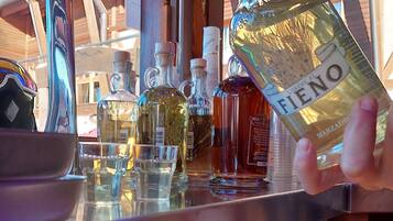 A bar area with a variety of liquor bottles and glasses on a counter.