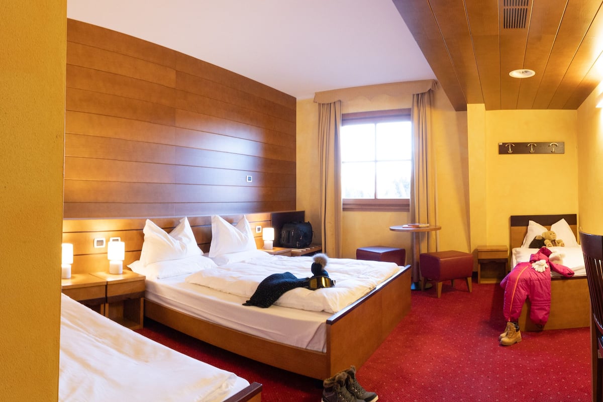 Ein Hotelzimmer mit Dusche, einem Bett, einem Nachttisch, einem kleinen Sitzbereich und einem Fenster.