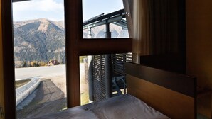 A bed with a view of a mountainous landscape through a window. - Hotel Enzo Moro (Sutrio)