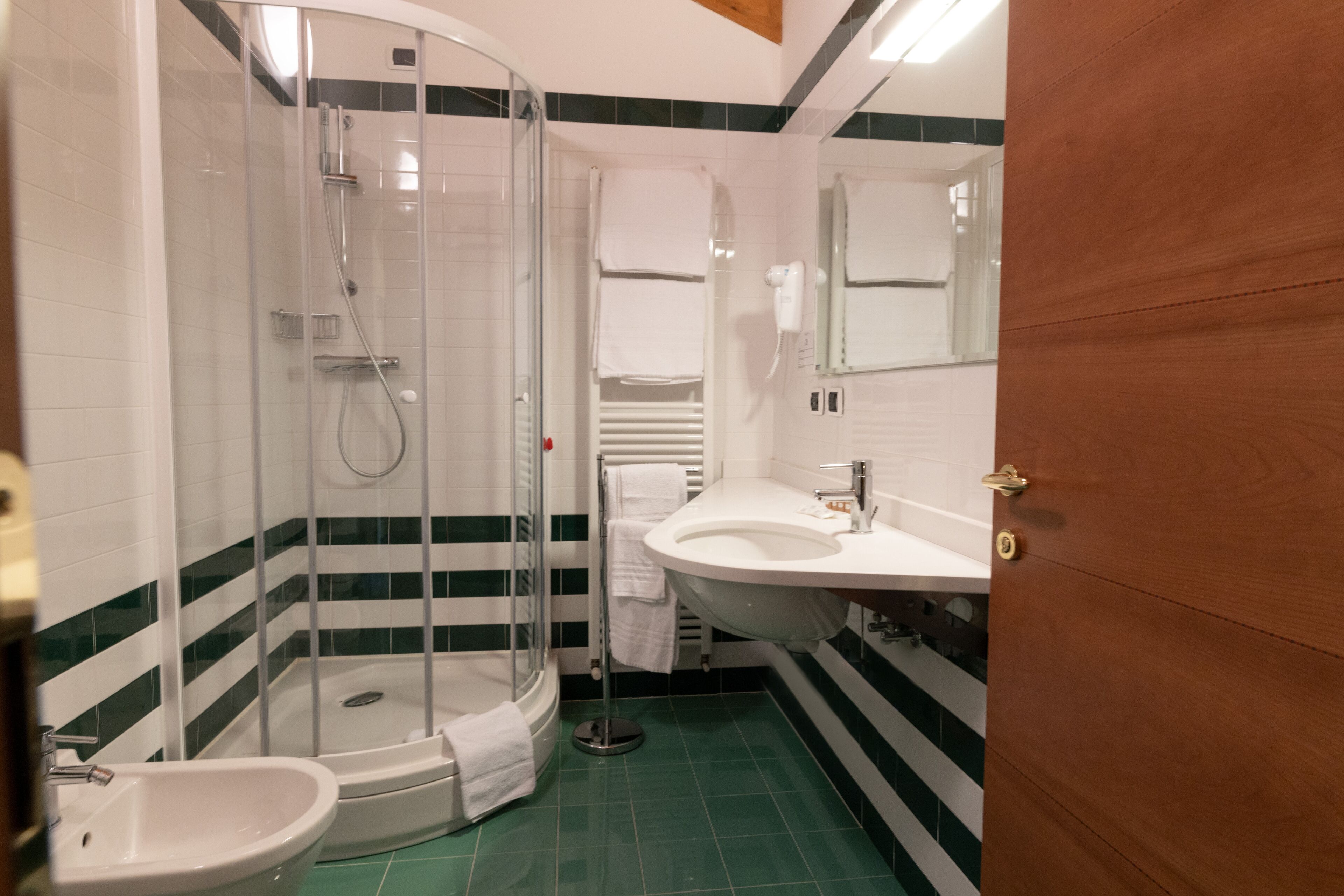 Une salle de bain avec une douche à parois de verre, un lavabo et des toilettes.