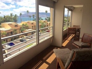 A balcony with a view of a coastal area, including buildings and a road.