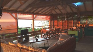 A spacious outdoor living area with a dining table, chairs, and a sofa. - Villa Zuli (Deshaies)