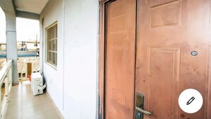 Una puerta de madera cerrada con manija de metal y un mirillón.