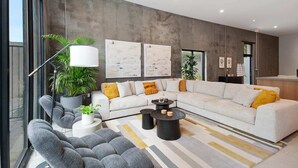 A modern living room with a sectional sofa, a coffee table, and a floor lamp. - Claudia | Sense of Calm and Relaxation,  Walking Distance to the Excitement - PO (New Orleans)
