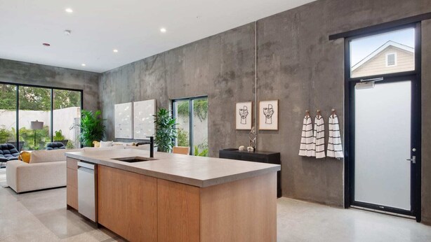 A modern kitchen with a large island, a dining area with a sofa, and a view of the outdoors. - Claudia | Sense of Calm and Relaxation,  Walking Distance to the Excitement - PO (New Orleans)