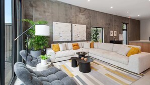 A modern living room with a large sectional sofa, a coffee table, and a potted plant. - Claudia - Unit 5 | Sense of Calm and Relaxation, Walking Distance to the Excitem (New Orleans)