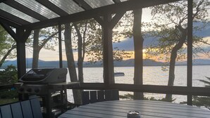 A covered outdoor area with a grill, a table, and a can of soda. - Lake & Mountain Retreat - Summer Adventures & Winter Escape (Center Ossipee)