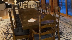 A spacious dining area with a large wooden table, multiple chairs, and a stone wall. - Lake & Mountain Retreat - Summer Adventures & Winter Escape (Center Ossipee)