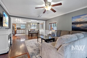 Relax in a spacious living area with a comfortable sectional sofa, dining table, and flat-screen TV.