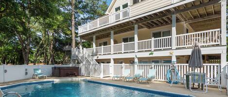 Guests can enjoy a relaxing poolside experience with lounge chairs and a table on the spacious balcony.