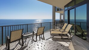 A balcony with a view of the ocean, furnished with chairs and a table. - The Oasis At Orange Beach 2706 by Liquid Life (Orange Beach)