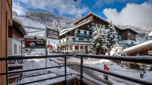 Un hôtel doté d’un restaurant et d’un service de location de matériel de ski, situé au milieu d’arbres couverts de neige et avec une vue imprenable sur les montagnes.