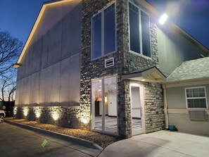 A modern building with a stone facade, large windows, and a garage. - Best Inn Motel (Salina)