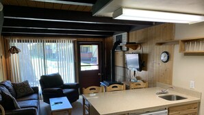 A compact living space with a kitchenette, a dining area, and a seating area with a sofa and chairs. - Condo in the mountains! (Red River)