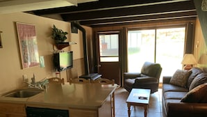 A compact living space with a kitchen, dining area, and a sofa. - Condo in the mountains! (Red River)