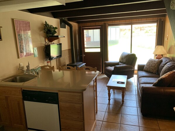 A compact living space with a kitchen, dining area, and a sofa. - Condo in the mountains! (Red River)