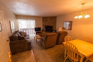 Relax in this inviting living room with a sofa, TV, and fireplace.