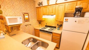 A kitchen with a stove, sink, microwave, and refrigerator. - Condo in the mountains! (Red River)