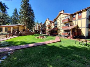 Traditional chalet-style hotel with a serene courtyard featuring lush greenery and a central bench.