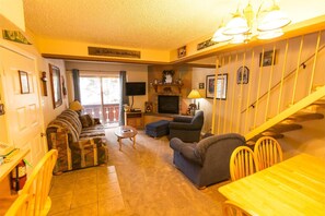 Cozy living room with a fireplace, comfortable seating, and a television, perfect for relaxing.