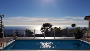 A swimming pool with a view of the ocean, surrounded by palm trees and a pergola. - Luxury villa with fantastic sea views (Adeje)