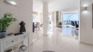 A modern, well-lit interior with a dining area, a living space with a view, and a clean, polished floor. - Luxury villa with fantastic sea views (Adeje)