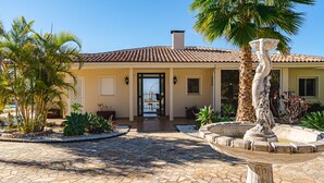 A house with a tiled roof, a stone-paved entrance, and a fountain with a statue. - Luxury villa with fantastic sea views (Adeje)