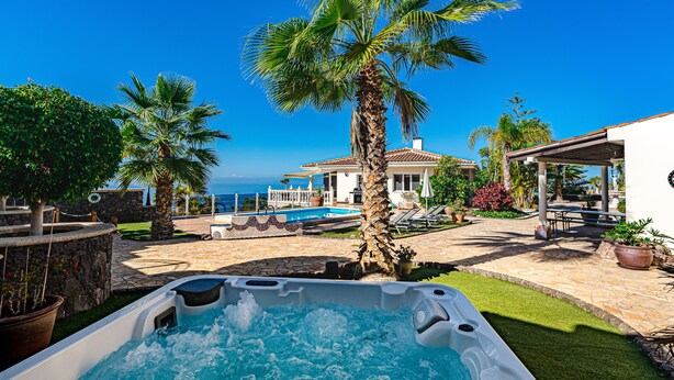 A hot tub with a view of a pool and a house with a patio. - Luxury villa with fantastic sea views (Adeje)