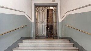 Un escalier surmonté d’une grille métallique et bordé de deux rampes de garde-corps.