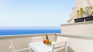 Ein Balkon mit einem Tisch für zwei Personen, einer Obstschale und Blick aufs Meer.