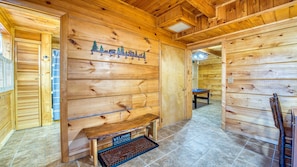 A wooden interior with a bench, a welcome sign, and a door with a bear decoration. - Smoky Mountains views from your porch! (Whittier)