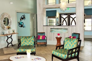 A lobby with three patterned armchairs, a round table with a vase, a mirror, and a painting on the wall. - 1-Story Disney Villa: Private Pool, Spa, Pickleball, Games (Davenport)