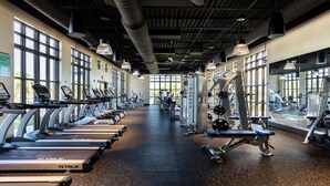 A gym with treadmills, elliptical machines, and weightlifting equipment.